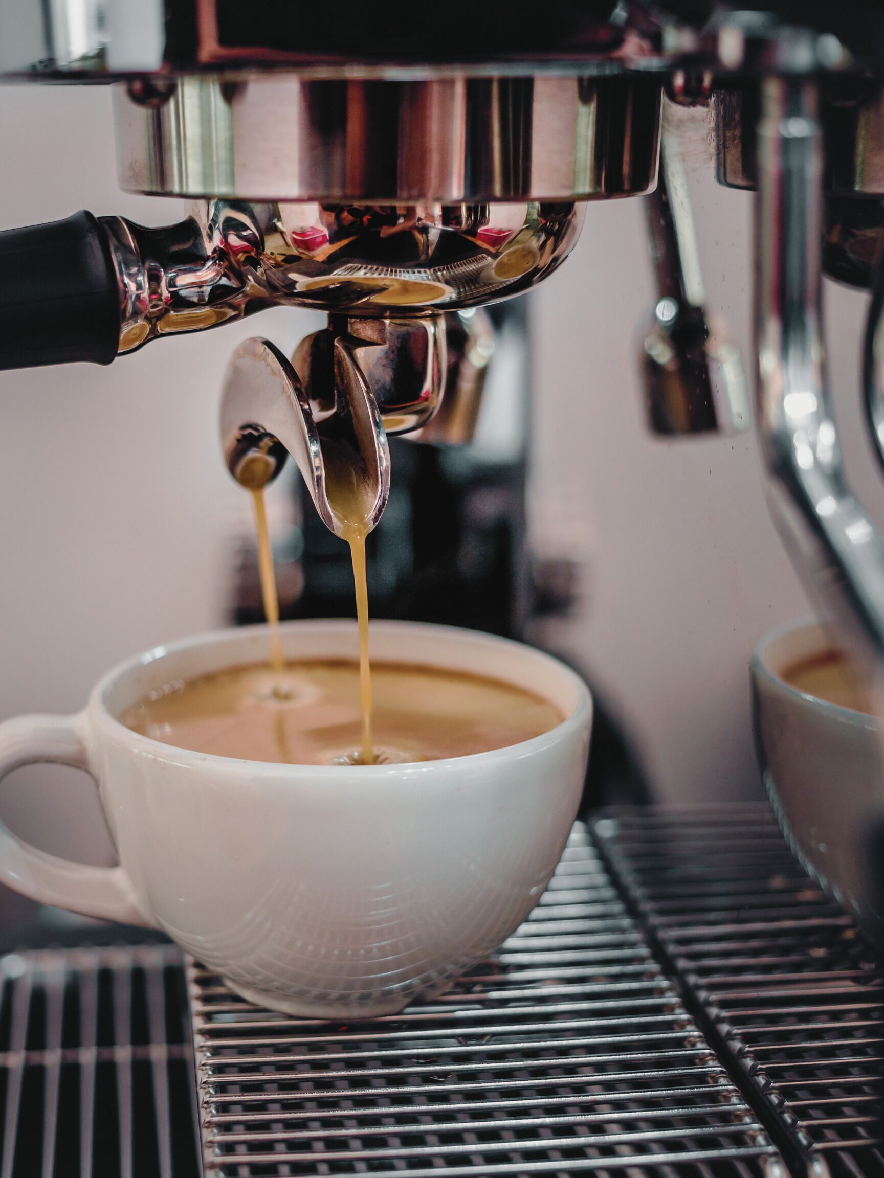 Una máquina de café sirviendo espresso en una taza.