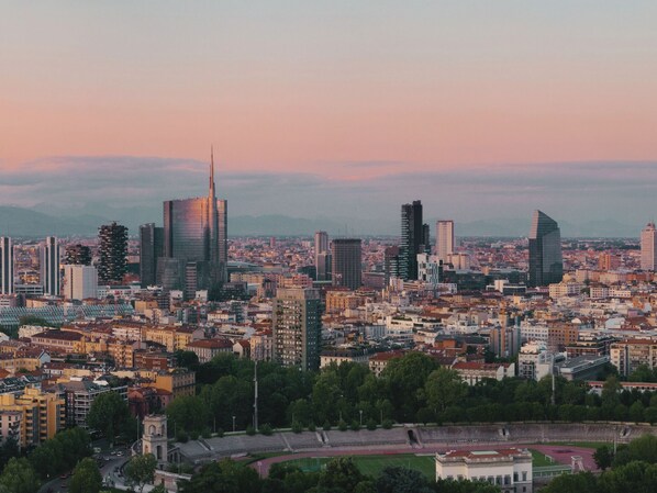 A cityscape with modern buildings, a stadium, and a clear sky. - Kleos Hotel Milano by Kleos Group Collection (Milan)