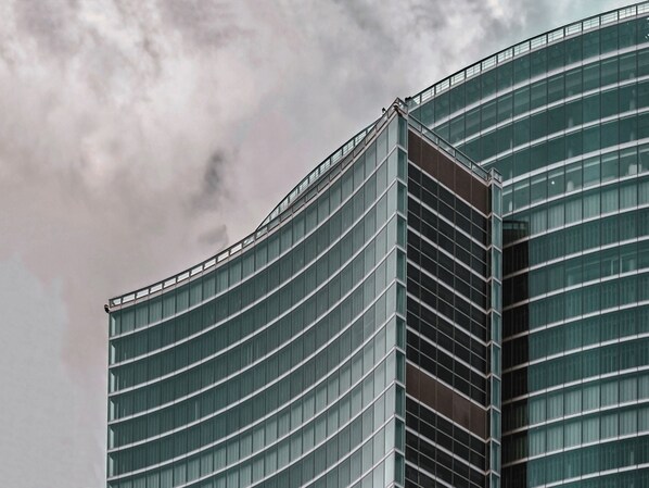 Een modern gebouw met een golvend gevelontwerp en grote ramen.