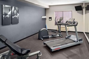 Stay active on your vacation with a fully equipped fitness room featuring a stationary bike, treadmill, and exercise bench.
