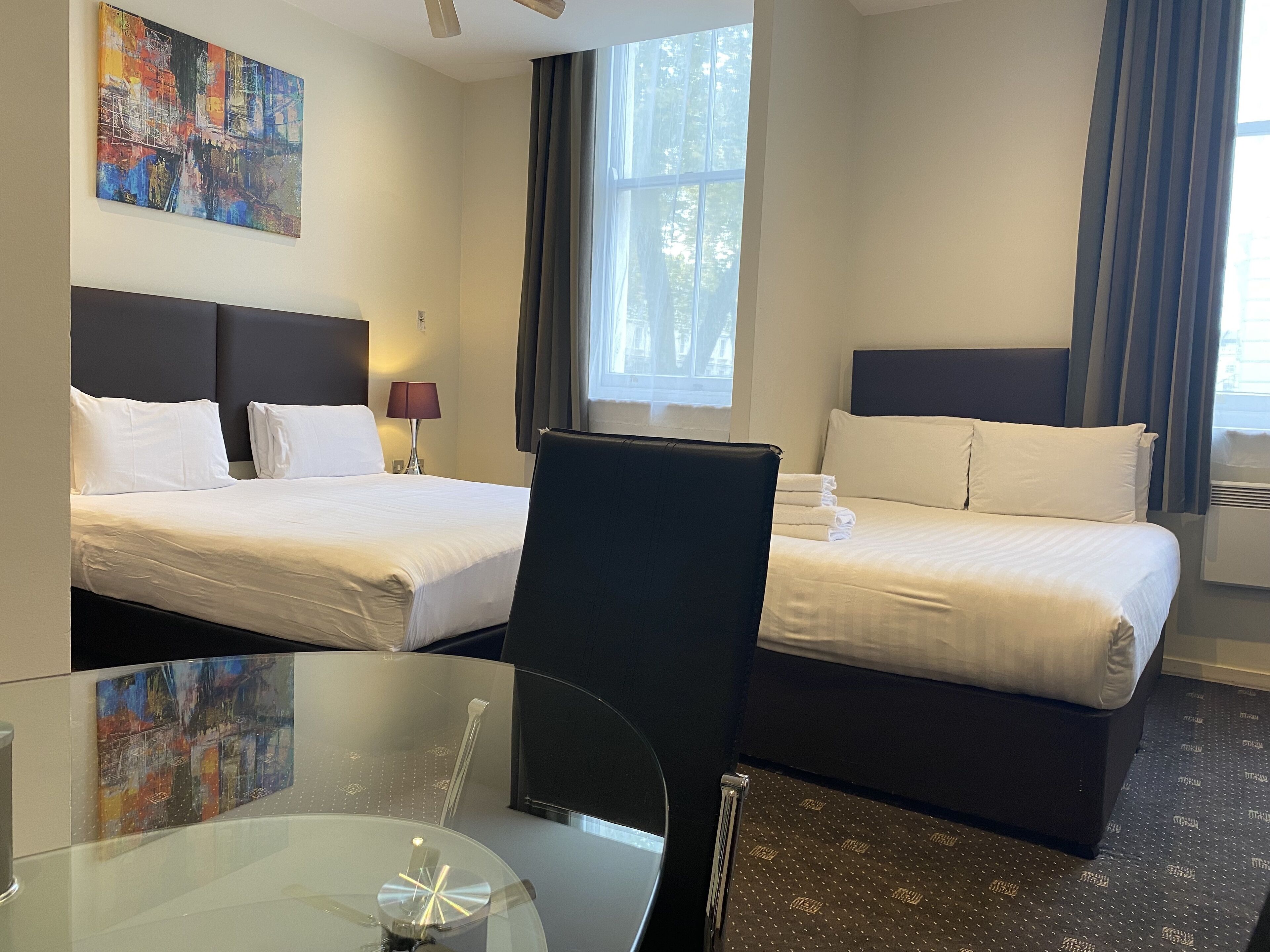 Ein Hotelzimmer mit zwei Betten, einem Schreibtisch und einem Stuhl.