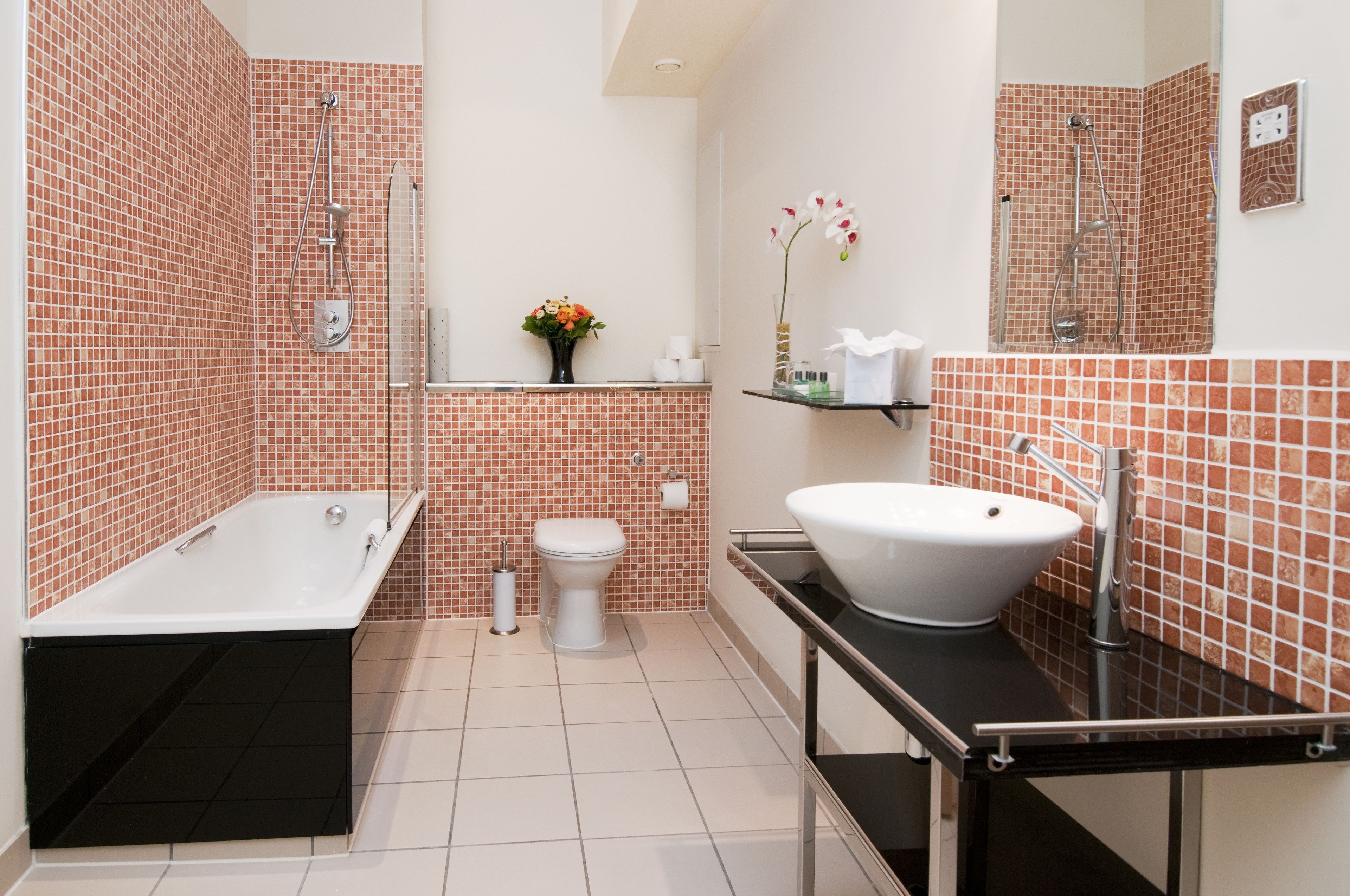 Een moderne badkamer met een bad, toilet en wastafel.