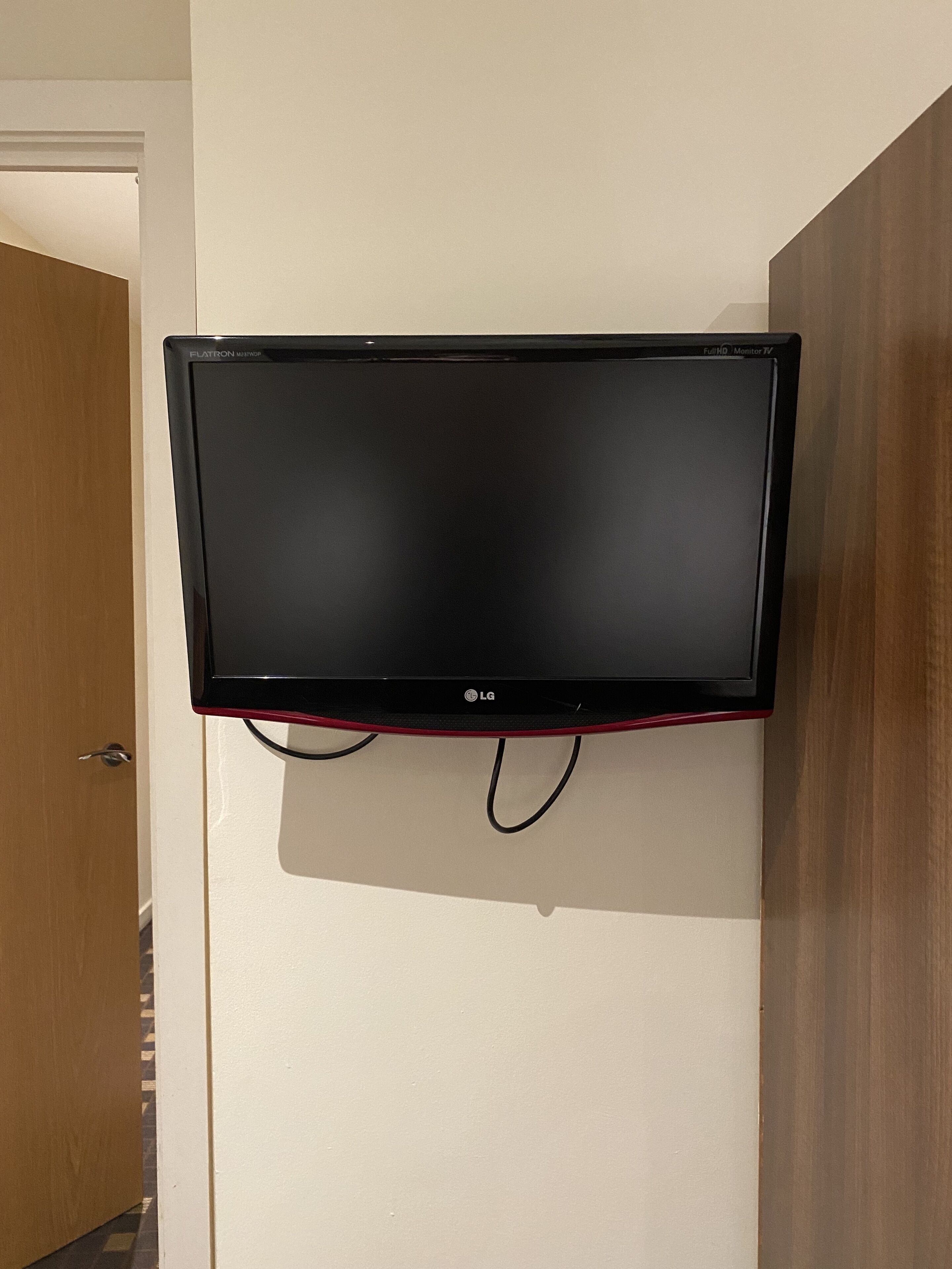 A flat-screen LG TV mounted on a wall in a hotel room.