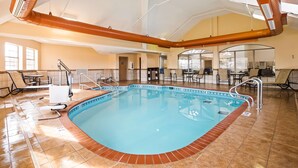 A large indoor swimming pool with a tiled floor, surrounded by lounge chairs and tables. - Best Western Plus Tulsa Inn & Suites (Tulsa)