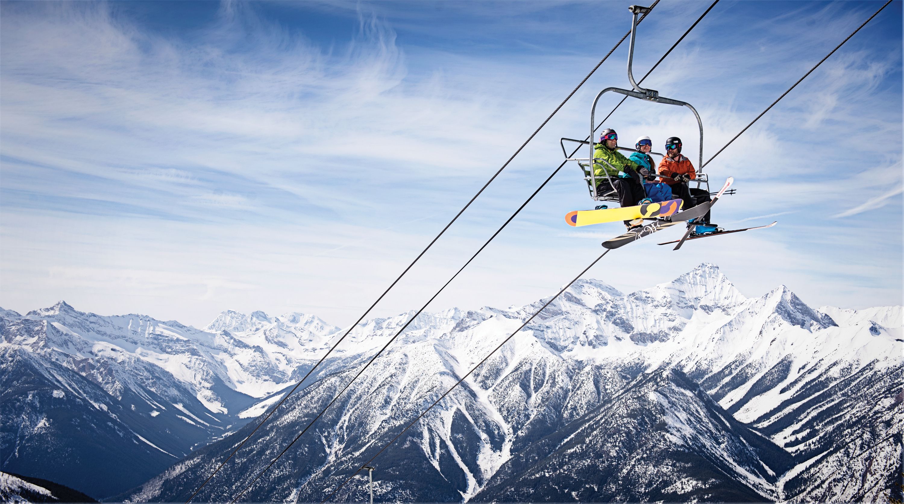 A ski lift with passengers and a mountainous landscape in the background.