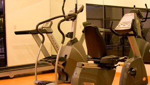 Un gimnasio con bicicletas estáticas y cintas de correr.