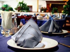 A dining table with a folded napkin, a glass of water, and a fork. - Royal Garden Reynosa (Reynosa)