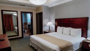Una habitación de hotel con una cama grande, una lámpara de noche, una mesita de noche y un espejo.