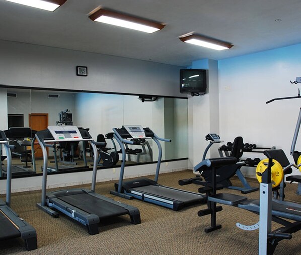 A gym with treadmills, weight machines, and a television on the wall. - Royal Garden Reynosa (Reynosa)