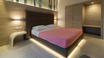 Una moderna camera da letto con un letto grande, poggiatesta integrato e illuminazione integrata.