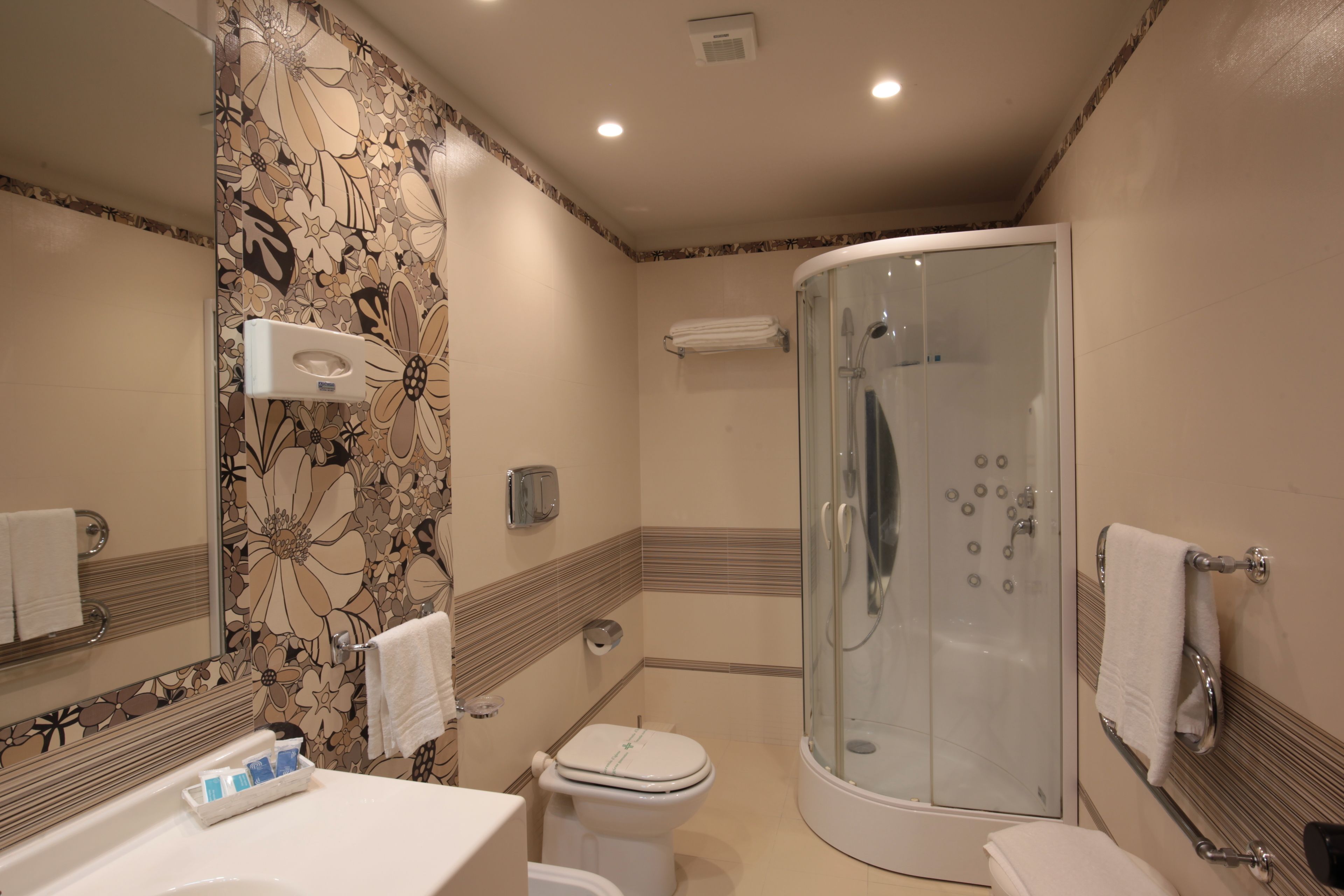 A bathroom with a shower, toilet, and sink.