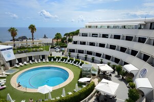 Una piscina al aire libre, sillones reclinables de piscina