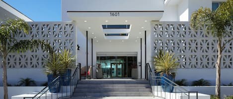 A modern building entrance with a staircase leading up to a door marked '1601'.