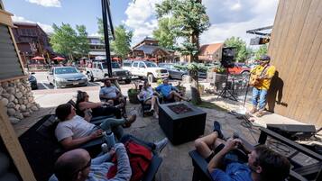 An outdoor seating area with stone walls, a fire pit, and a stage for live music.