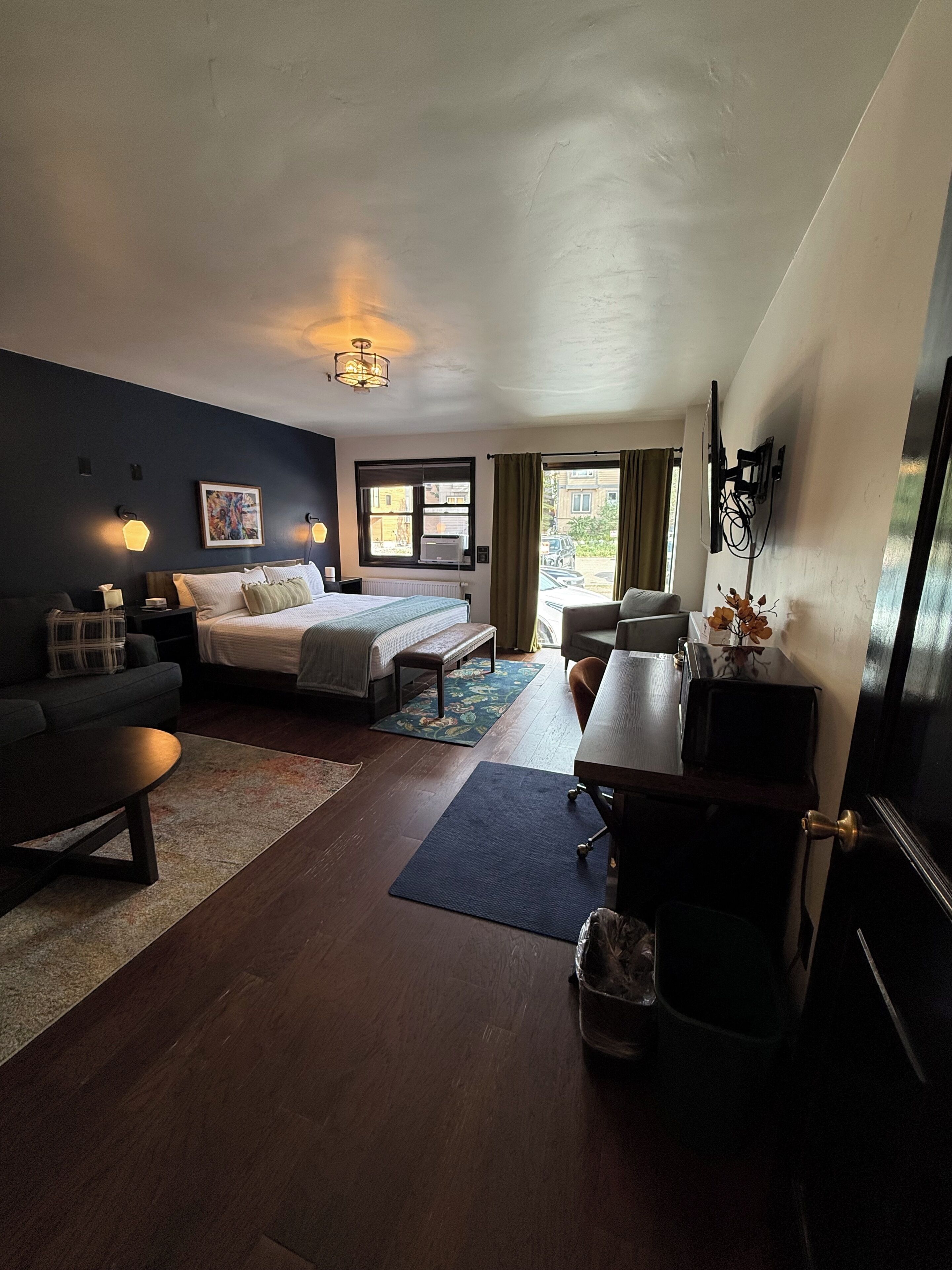 Une chambre d’hôtel équipée d’un lit, d’un bureau, d’une chaise, d’un canapé et d’une télévision.