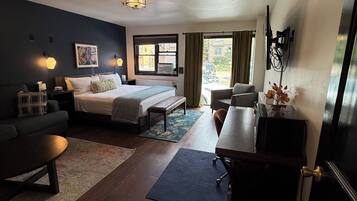 Une chambre d’hôtel équipée d’un lit, d’un bureau, d’une chaise, d’un canapé et d’une télévision.