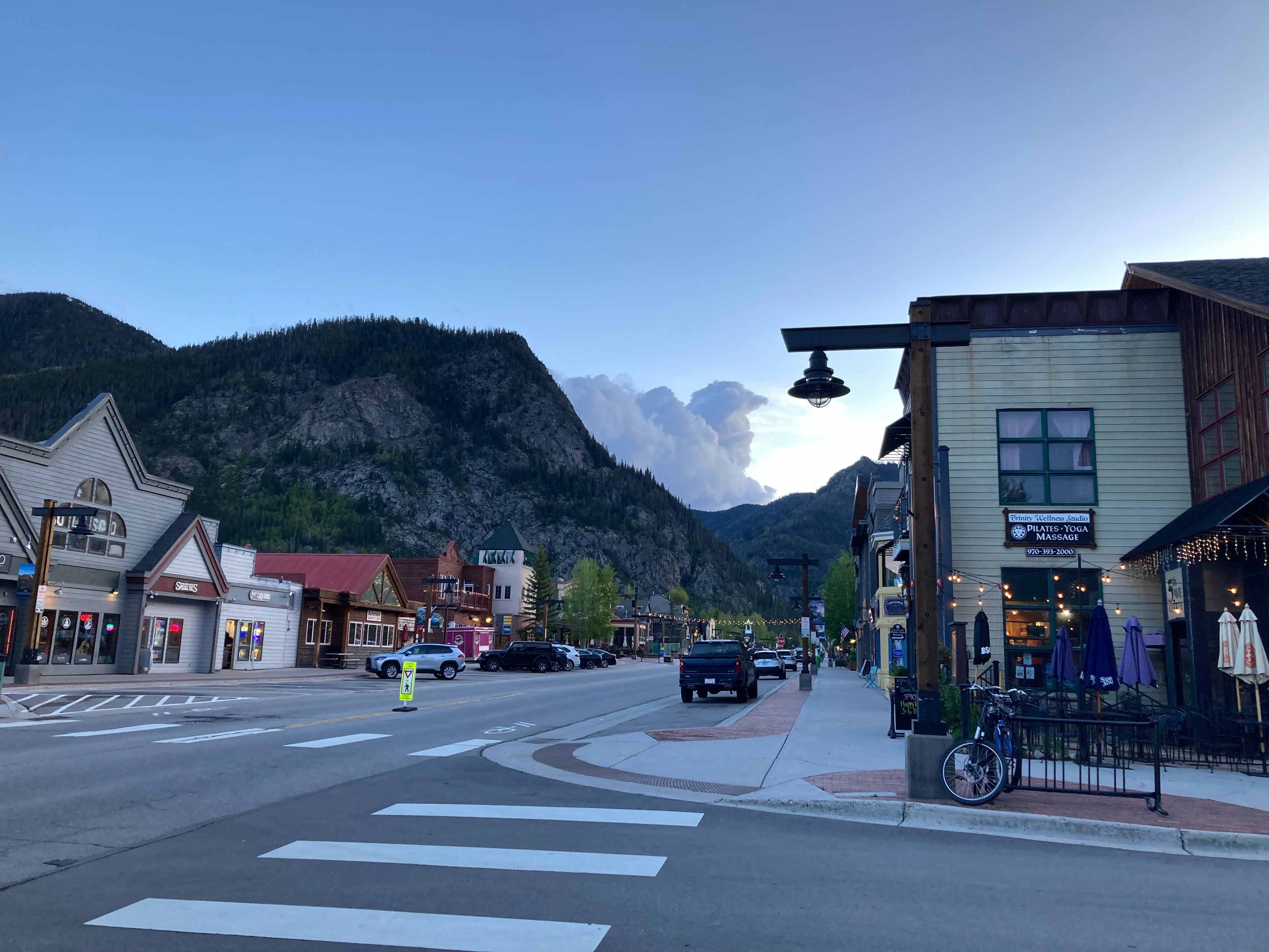 A street with buildings, a mountain in the background, and a crosswalk.