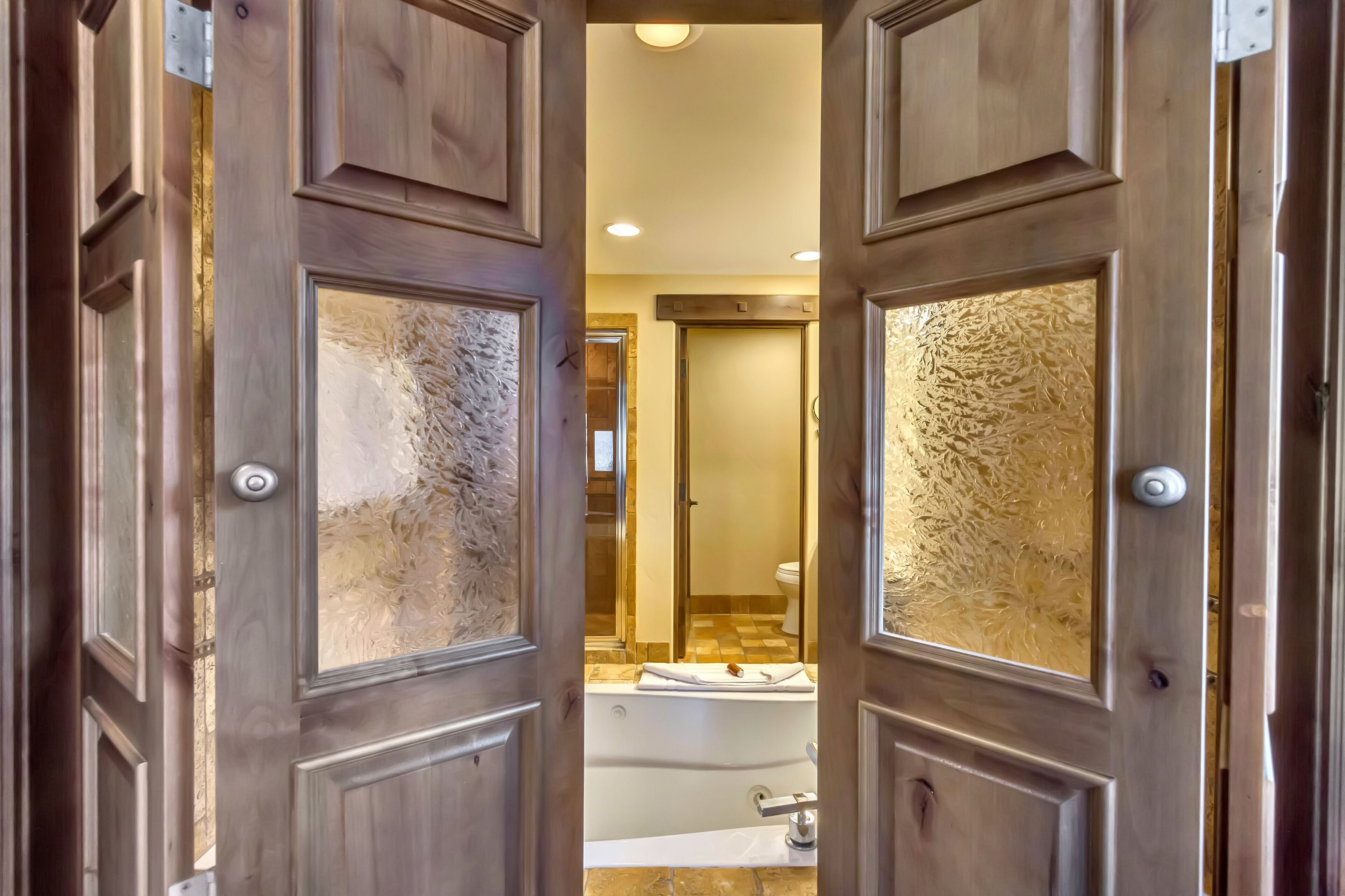 A bathroom with a bathtub, toilet, and mirror.