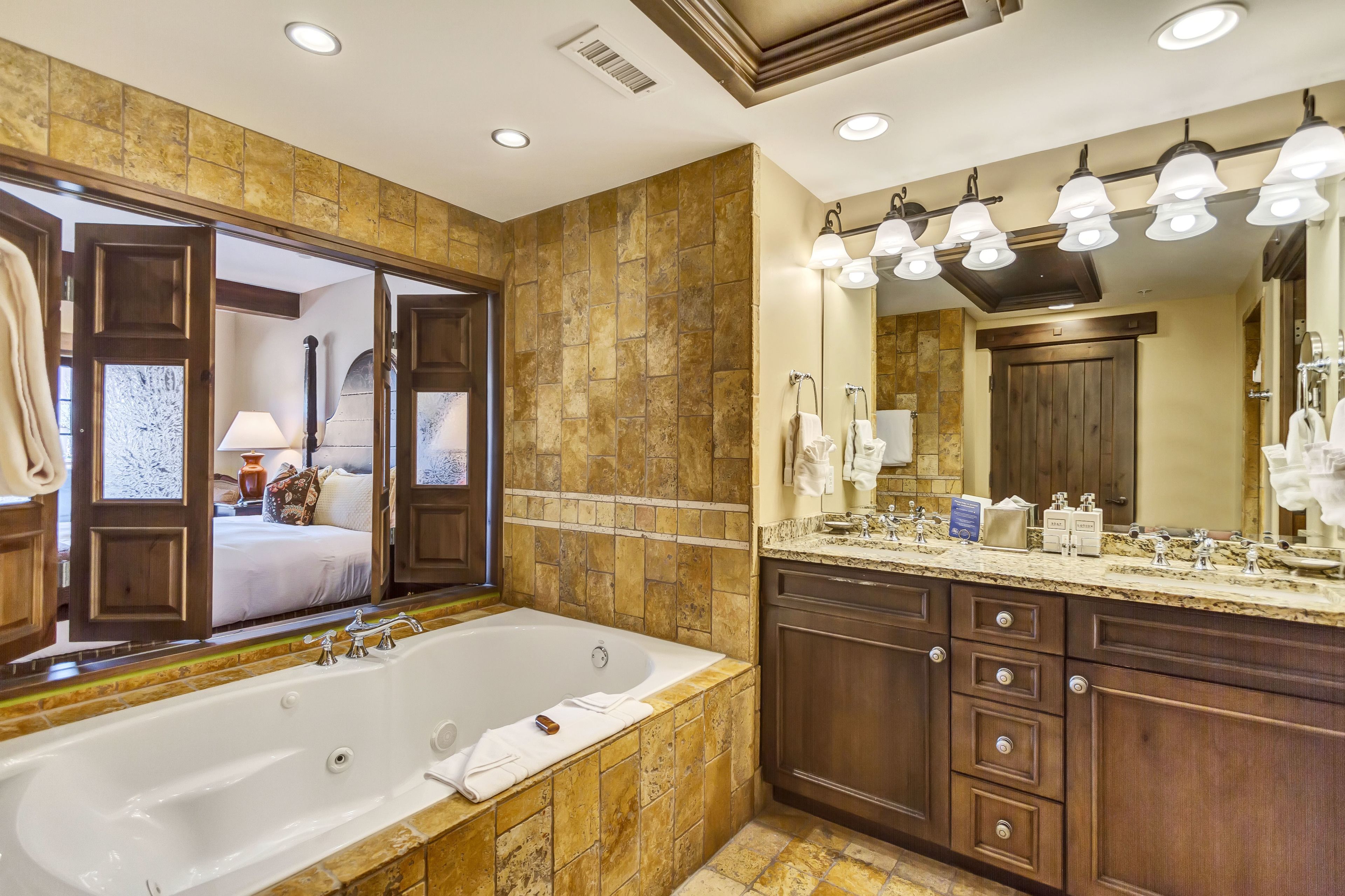A spacious bathroom with a large bathtub, a vanity with a mirror, and a shower area.