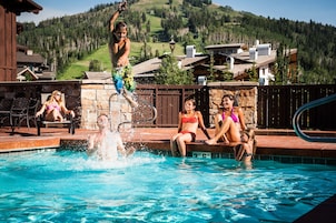 Una piscina al aire libre, sillones reclinables de piscina