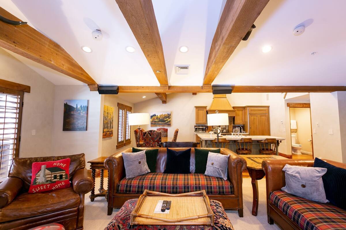 Ein gemütliches Wohnzimmer mit Kamin, Ledersofas und einem Essbereich mit Holzmöbeln.