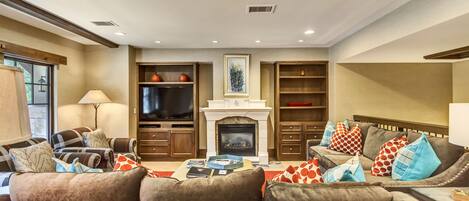 A living room with a fireplace, sofas, and a television.
