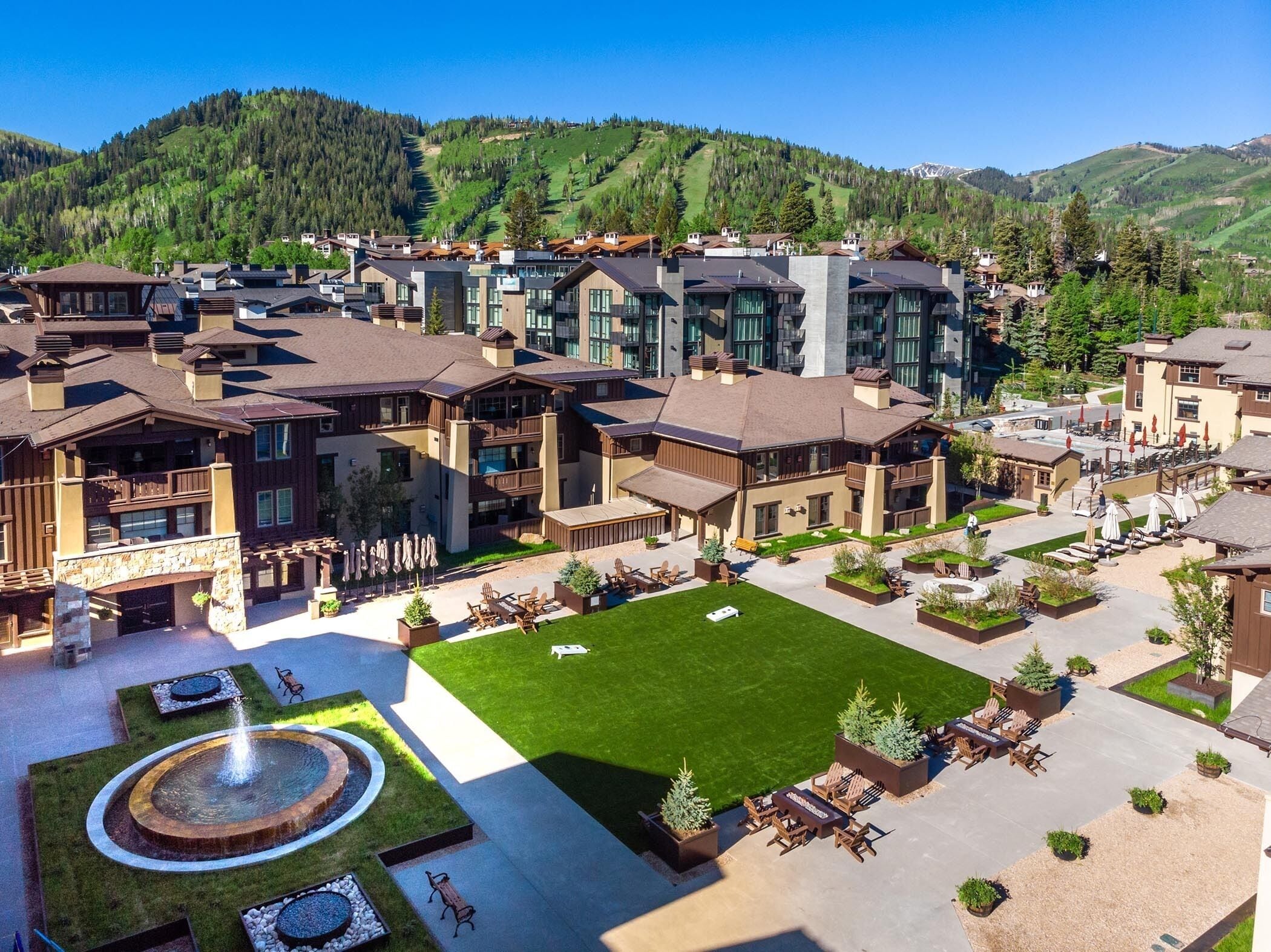 Un resort con varias edificaciones, zonas de estar al aire libre y un césped central.
