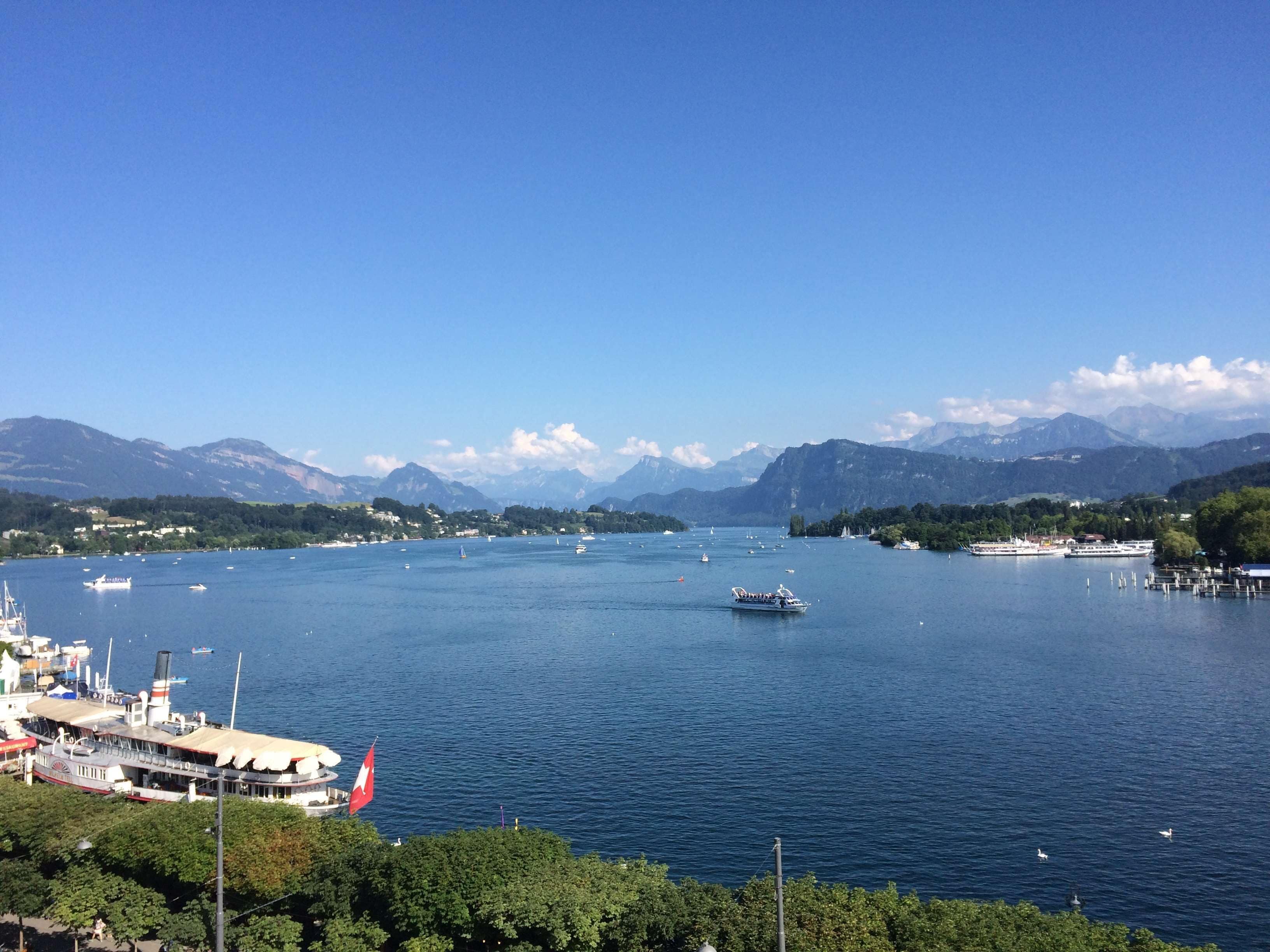 A lake with boats, a dock, and mountains in the background.