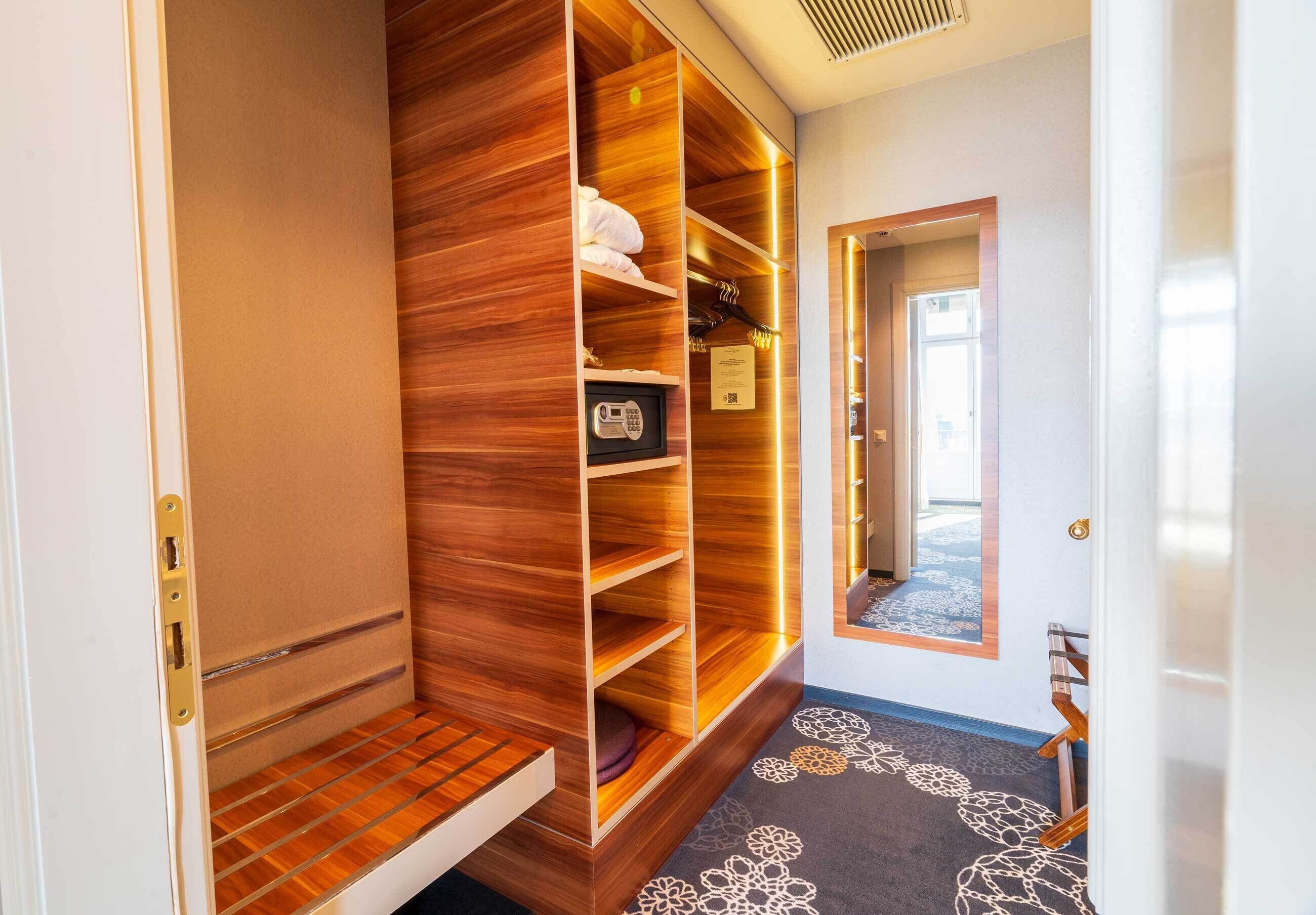 Une chambre d’hôtel avec une armoire en bois, un téléphone et une moquette à motifs floraux.