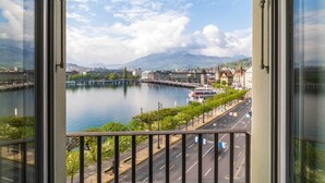 A river view from a balcony with a cityscape, including buildings and a mountain in the distance. - Hotel Schweizerhof Luzern (Lucerne)