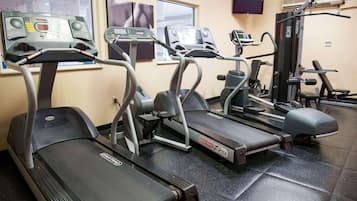 A gym with treadmills, elliptical machines, and weight equipment.