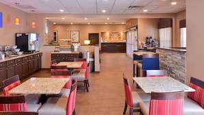 A hotel lobby with multiple seating areas, a reception desk, and a kitchen in the background. - Comfort Inn & Suites Fayetteville - University Area (Fayetteville)