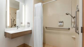 A modern bathroom with a shower, a sink, and a mirror.