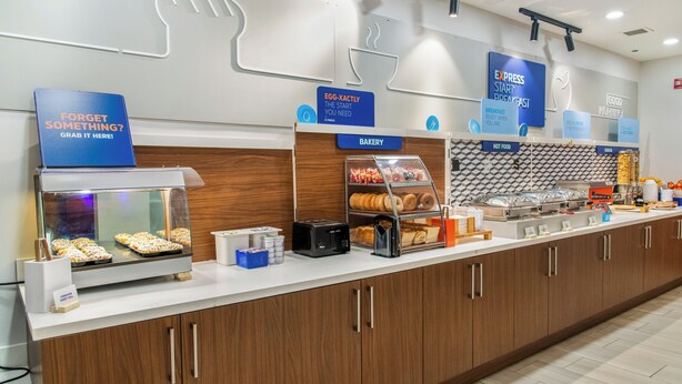 A breakfast bar with various food items and a sign that says "Egg-Xactly The Start You Need". - Holiday Inn Express Hotel & Suites Pittsburgh-South Side by IHG (Pittsburgh)