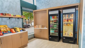 A snack bar with a variety of chips, a refrigerator stocked with beverages, and a display of packaged goods. - Holiday Inn Express Hotel & Suites Pittsburgh-South Side by IHG (Pittsburgh)