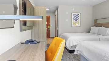 Hotellihuone, jossa on sänky, työpöytä, tuoli, puhelin ja taulu seinällä.