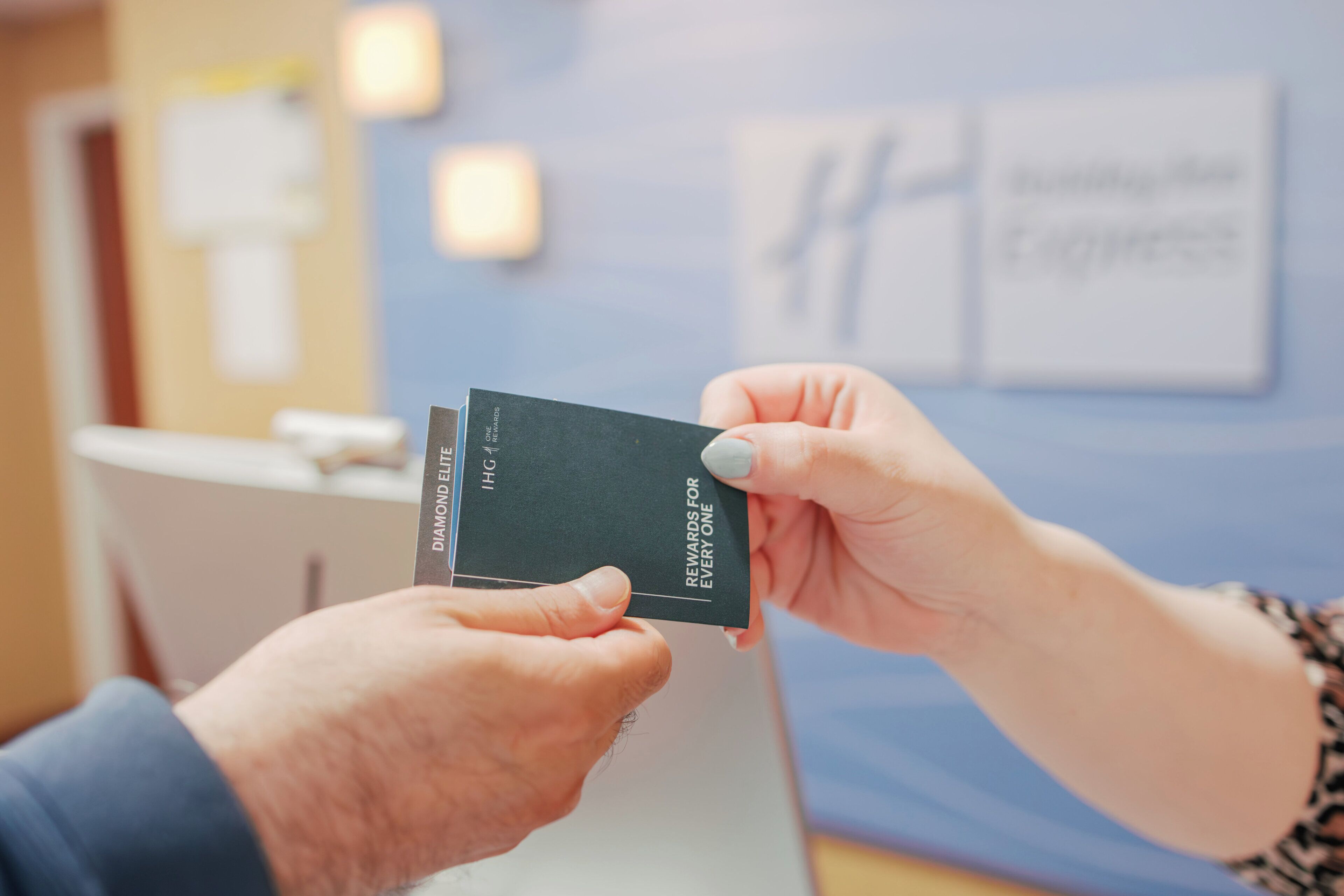 Une personne tenant une carte sur laquelle figurent les mentions « Diamond Elite » et « Des récompenses pour tous ».