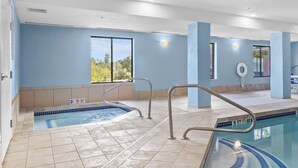 An indoor swimming pool with clear water, tiled floor, and metal handrails. - Holiday Inn Express Hotel & Suites Manchester Airport by IHG (Manchester)