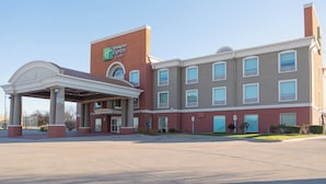 A Holiday Inn Express hotel with a covered entrance, multiple windows, and a brick facade. - Holiday Inn Express Hotel & Suites Gainesville by IHG (Gainesville)
