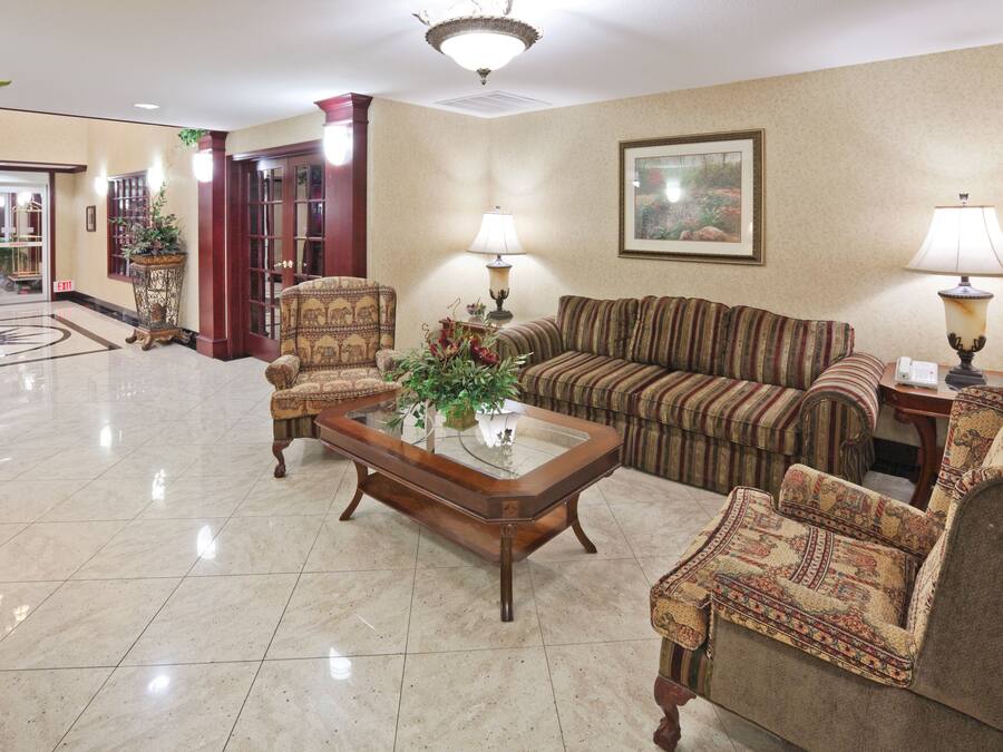 A lobby with a coffee table, armchairs, a sofa, and lamps.