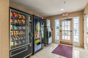 A vending machine area with snacks and a refrigerator. - HomeTowne Studios & Suites by Red Roof Charlotte - Concord (Concord)