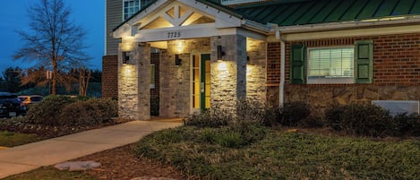 A building with a stone facade, a numbered entrance, and a green awning.