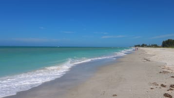 Een privéstrand, wit zand, strandlakens