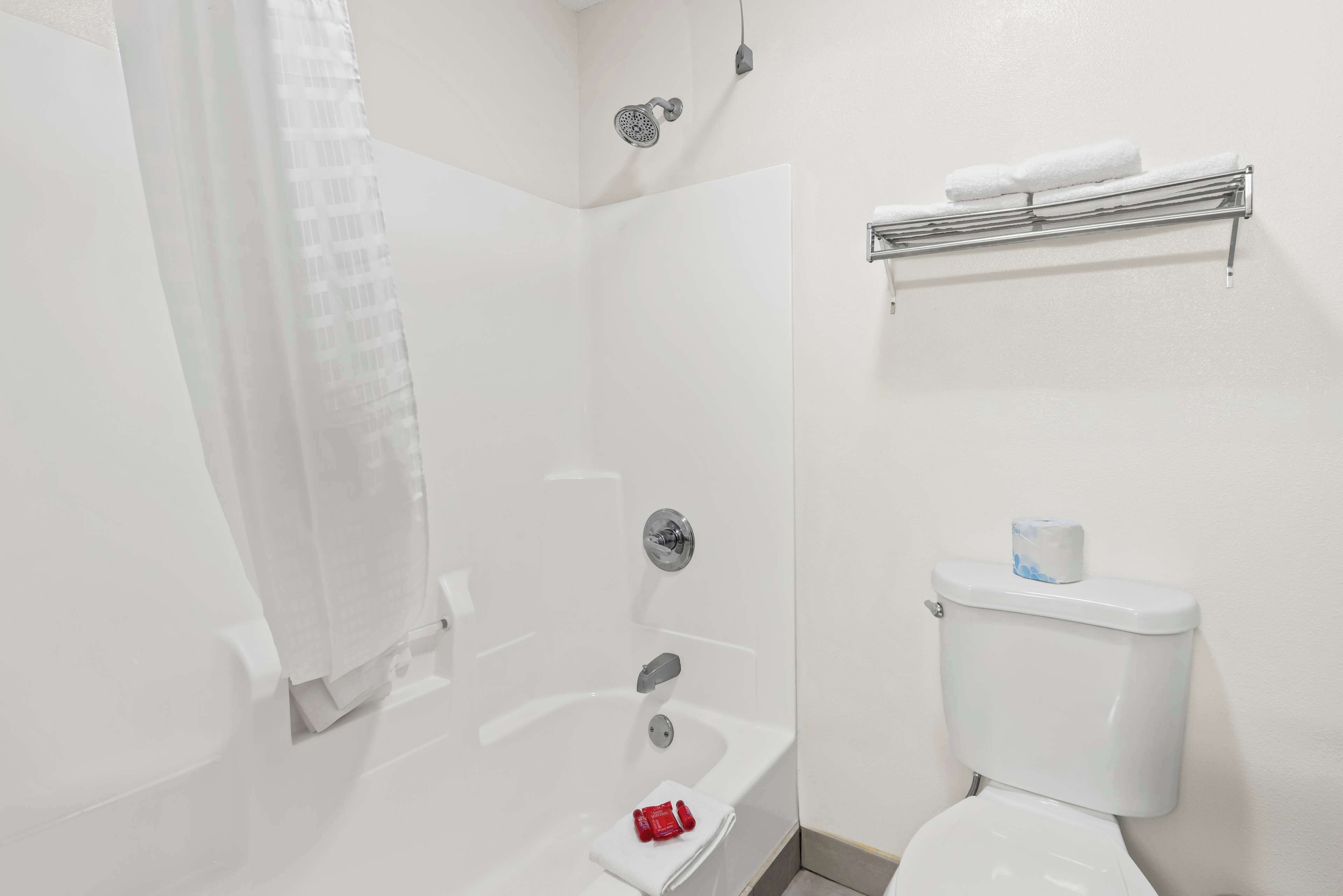 Un baño con bañera, inodoro, ducha y toallero.