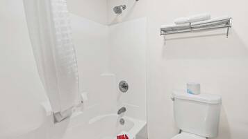 Un baño con bañera, inodoro, ducha y toallero.