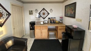 Eine kleine Küche mit Kaffeemaschine, Toaster und Obstschale.