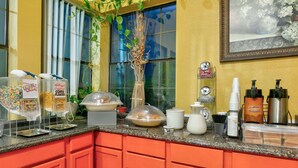 A breakfast bar with cereal, coffee, and condiments.