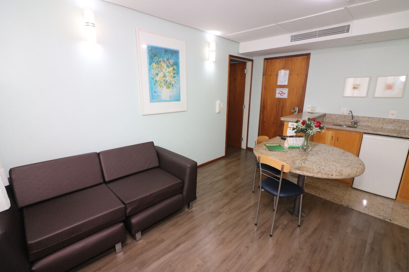 A compact living space with a sofa, a small dining table, and a kitchenette.