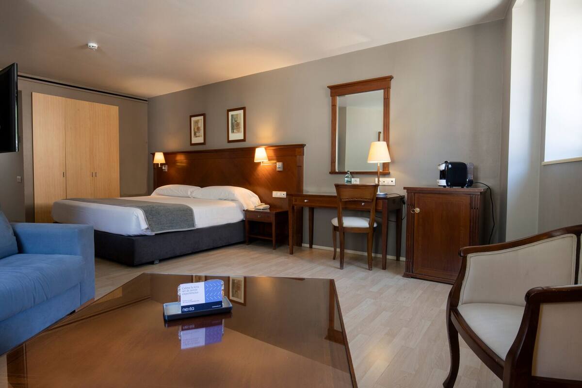Une chambre d’hôtel équipée d’un lit, d’un bureau, d’une chaise et d’une machine à café.