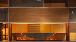 Een modern interieur met een inbouwvuurplaats, houten lambrisering en een zithoek.